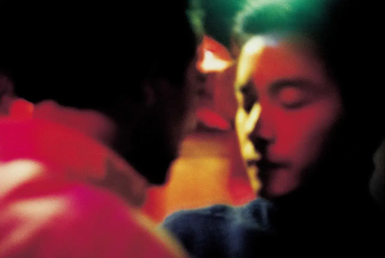 Un bacio intenso, un momento di passione tra due persone. L'atmosfera è carica di emozione, quasi come un sogno, un ricordo sfocato di Wing Shya.