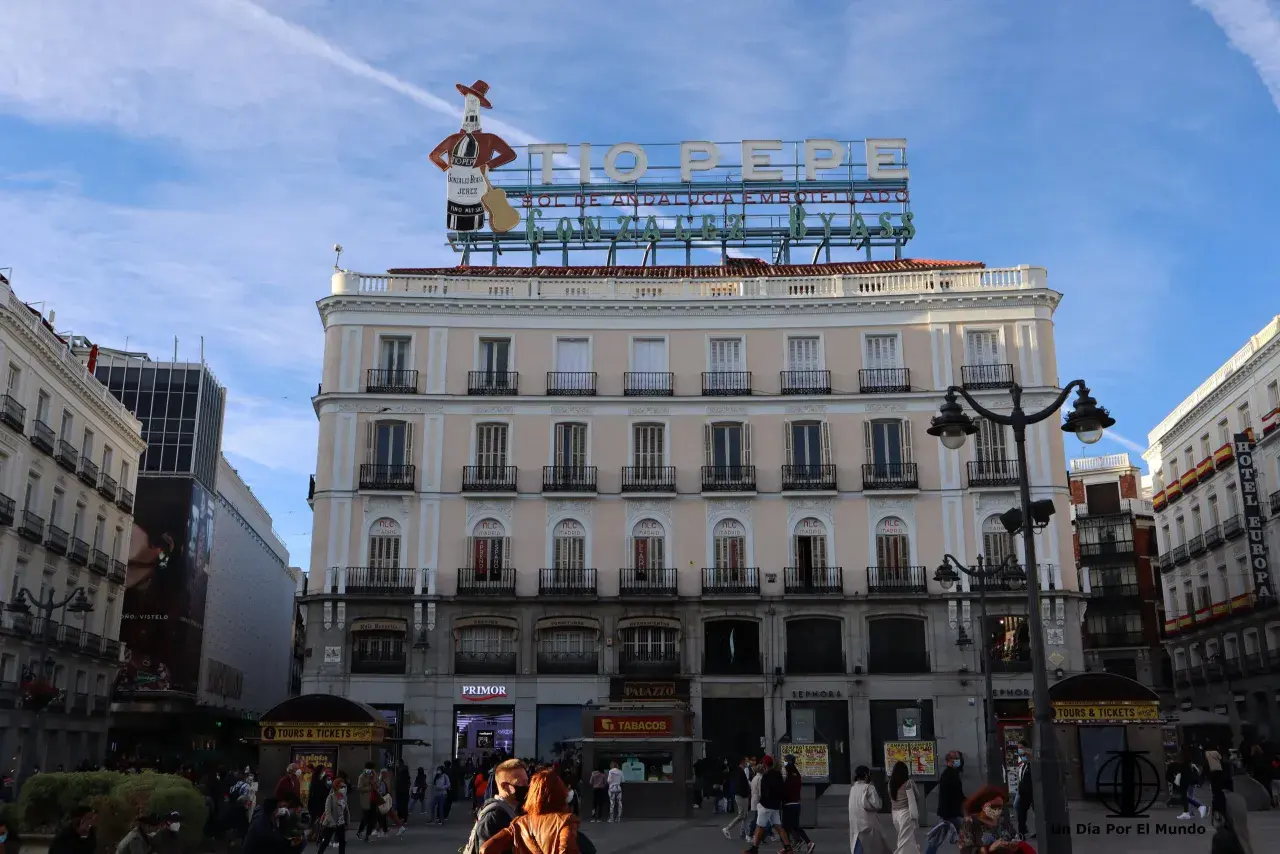 Edificio emblemático en la Puerta del Sol, Madrid. Ideal para saber qué ver en Madrid en un día, con el cartel de Tío Pepe y gente paseando.