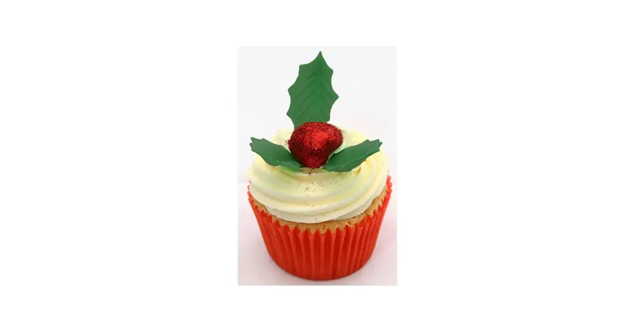 Un cupcake festif orné d'une baie rouge pailletée et d'une feuille de houx verte.