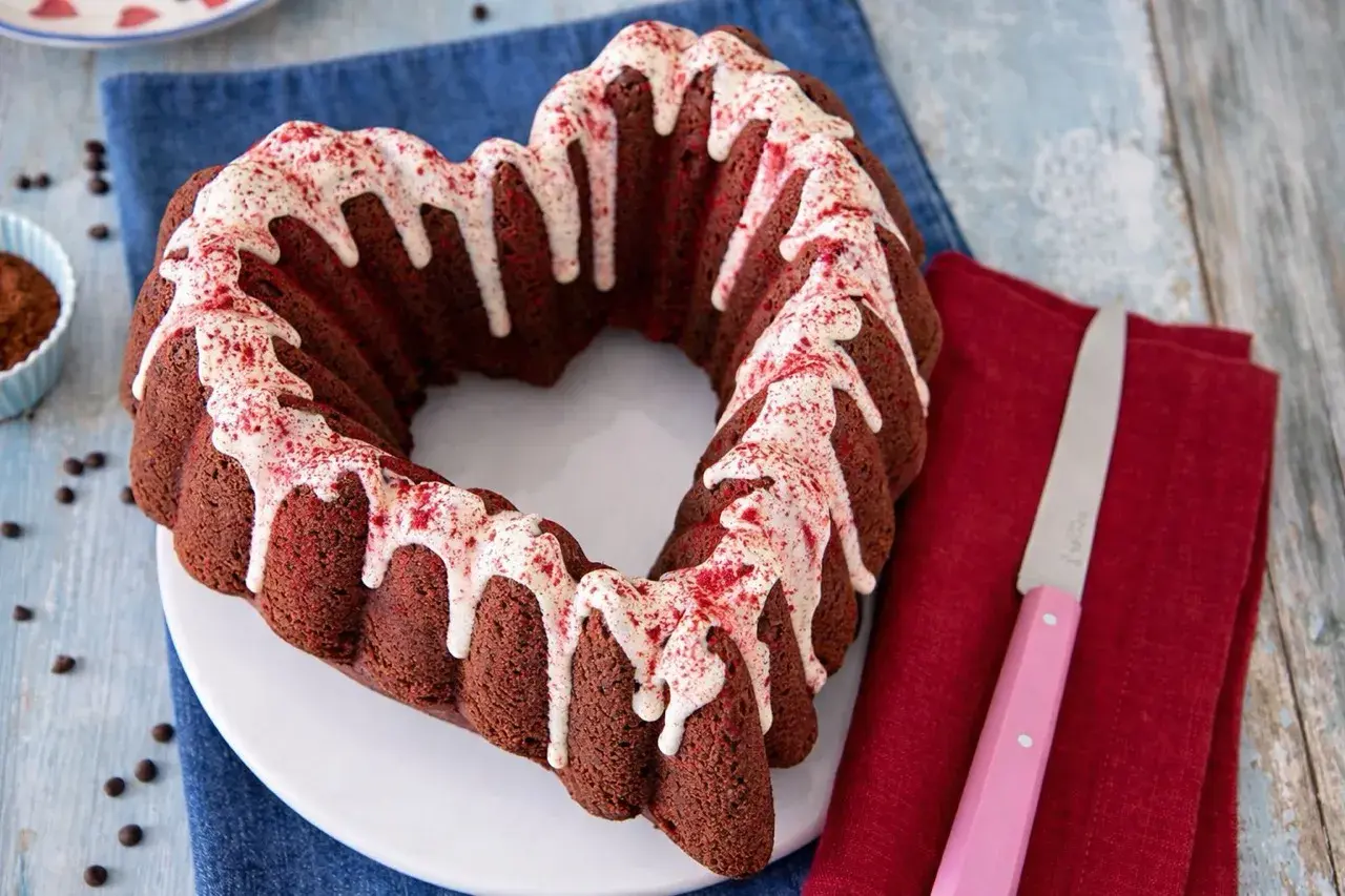 Cuore di torta barbabietola e cioccolato, glassato con glassa bianca e spolverata di polvere rossa.