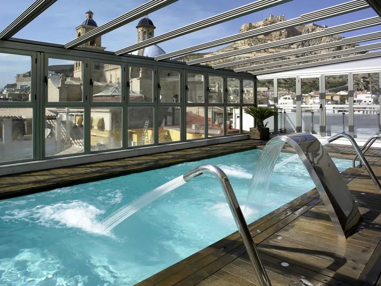 Piscina con cascadas y vistas a la ciudad, ideal para un spa bodyna Valencia.