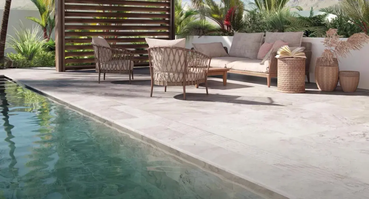 Terraza junto a piscina con mobiliario de exterior. El suelo antideslizante es el mejor suelo para exterior, seguro y elegante.