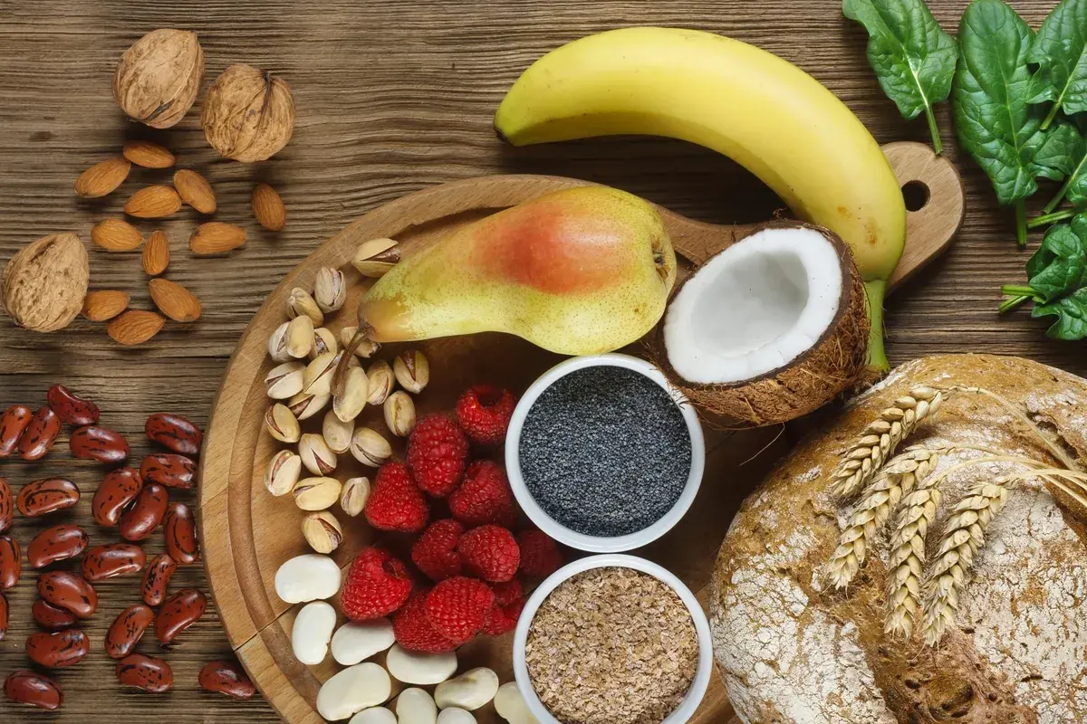Frutta, noci, semi, legumi e pane integrale: un'abbondanza di cibi ricchi di fibre per una dieta sana.