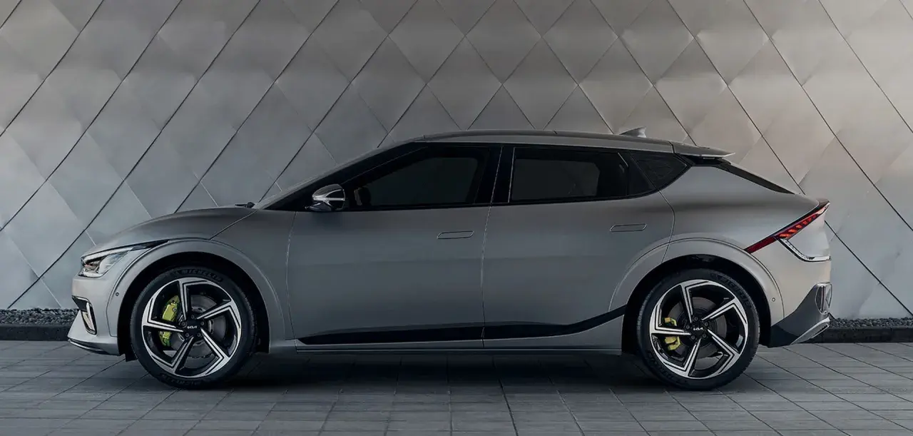 Szary Kia EV6 na tle geometrycznej ściany. Sprawdź atrakcyjną kia ev6 cena i zamów już dziś!