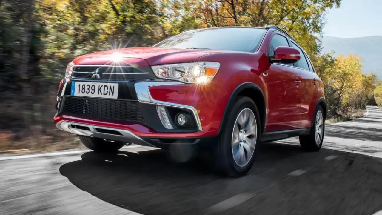 Un Mitsubishi ASX rojo circula por una carretera rural. A pesar de su diseño, algunos propietarios han reportado problemas del Mitsubishi ASX.