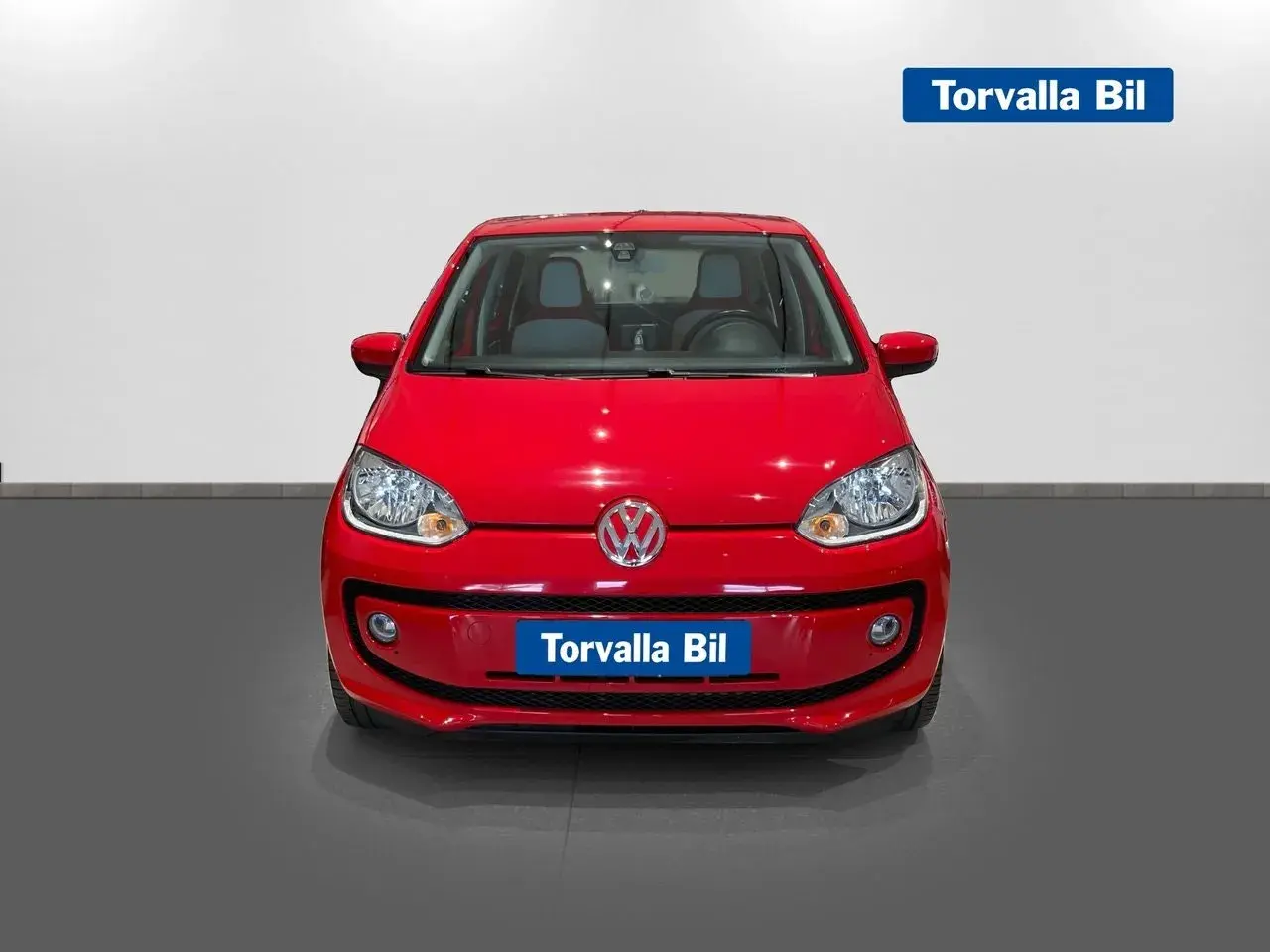Röd Volkswagen Up, en perfekt begagnad bil för stadskörning.