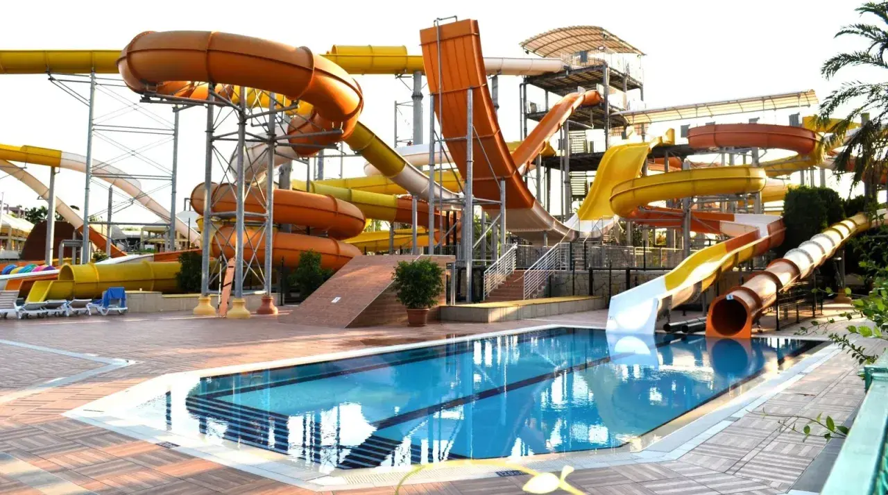Wodny park rozrywki w Turcji, idealny na upalną pogodę w sierpniu. Kolorowe zjeżdżalnie i basen zapraszają do zabawy.