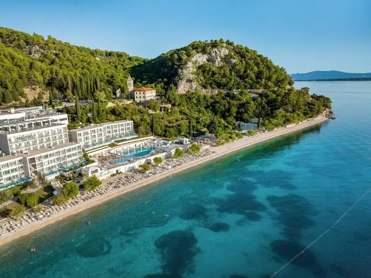 Traumhafter TUI Blue Adriatic Beach mit kristallklarem Wasser, weißen Hotels und grünen Hügeln. Ein Paradies zum Entspannen.