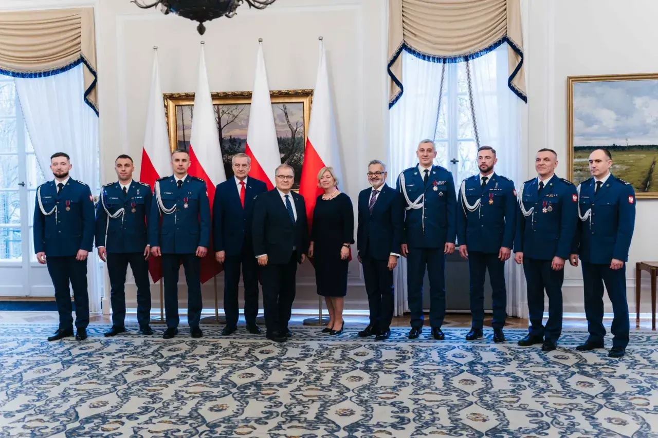 Grupa osób w mundurach i garniturach, być może związana z sekrety ochrony prezydenta i incydenty z drona pod rezydencją w marcu 2026.