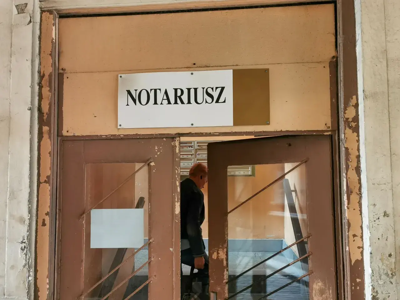 Mężczyzna wchodzi do biura notariusza, gdzie może sporządzić testament.