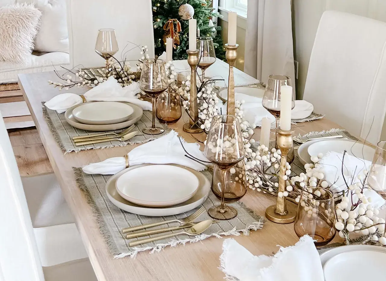 Elegant Christmas tablescapes featuring gold accents, white berry branches, and amber glassware.