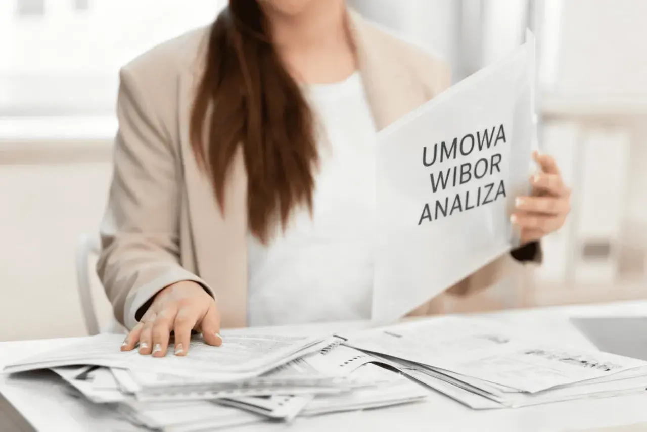 Kobieta w marynarce przegląda dokumenty z napisem "Umowa WIBOR Analiza".