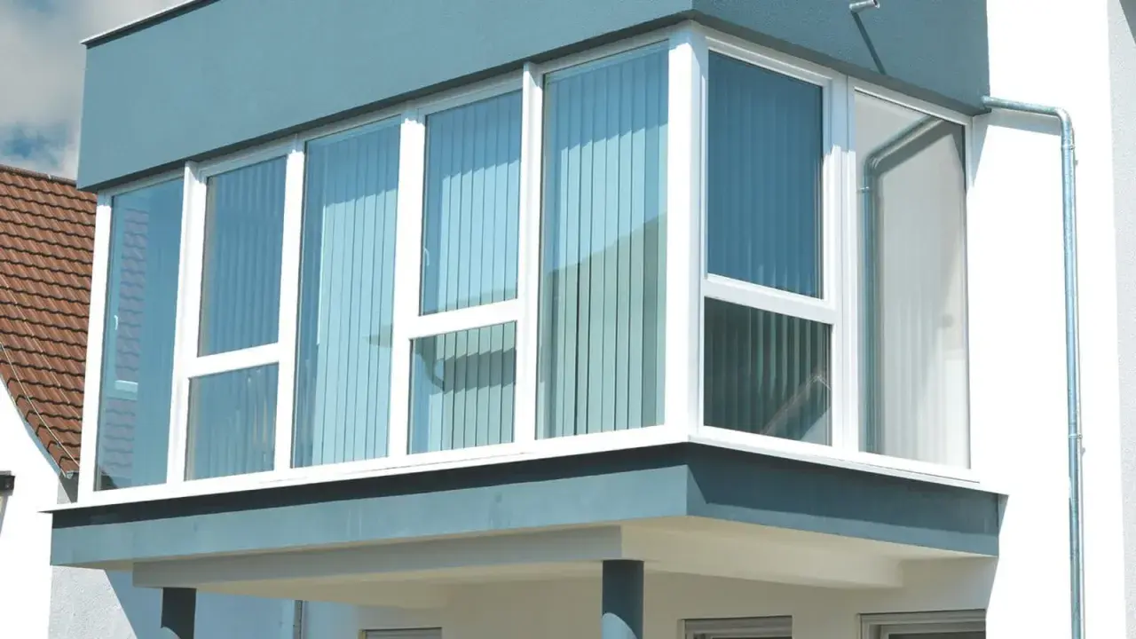 Moderner Anbau mit großen Fenstern, der einen Balkon zum Wintergarten umbauen lässt.