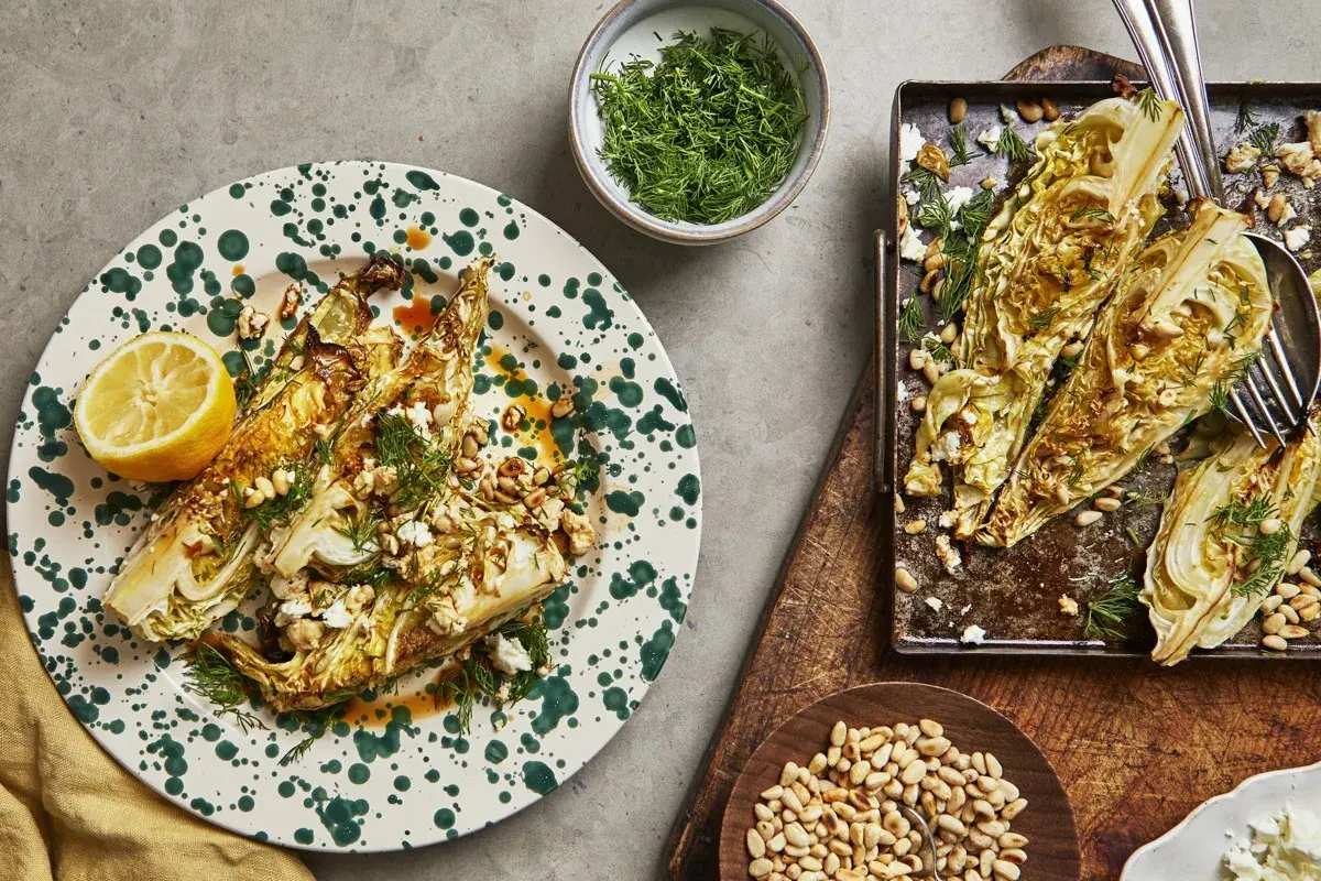 Ugnsbakad spetskål i soja, toppad med fetaost, pinjenötter och dill. Serveras med citronklyfta.