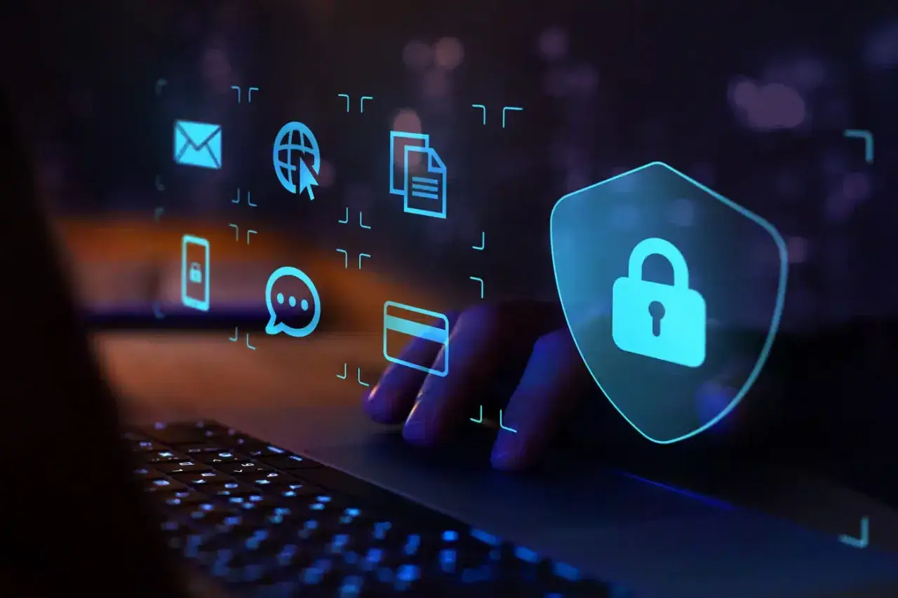 Ręce na klawiaturze, ikony symbolizujące dane i bezpieczeństwo. Jak chronić się przed malware?