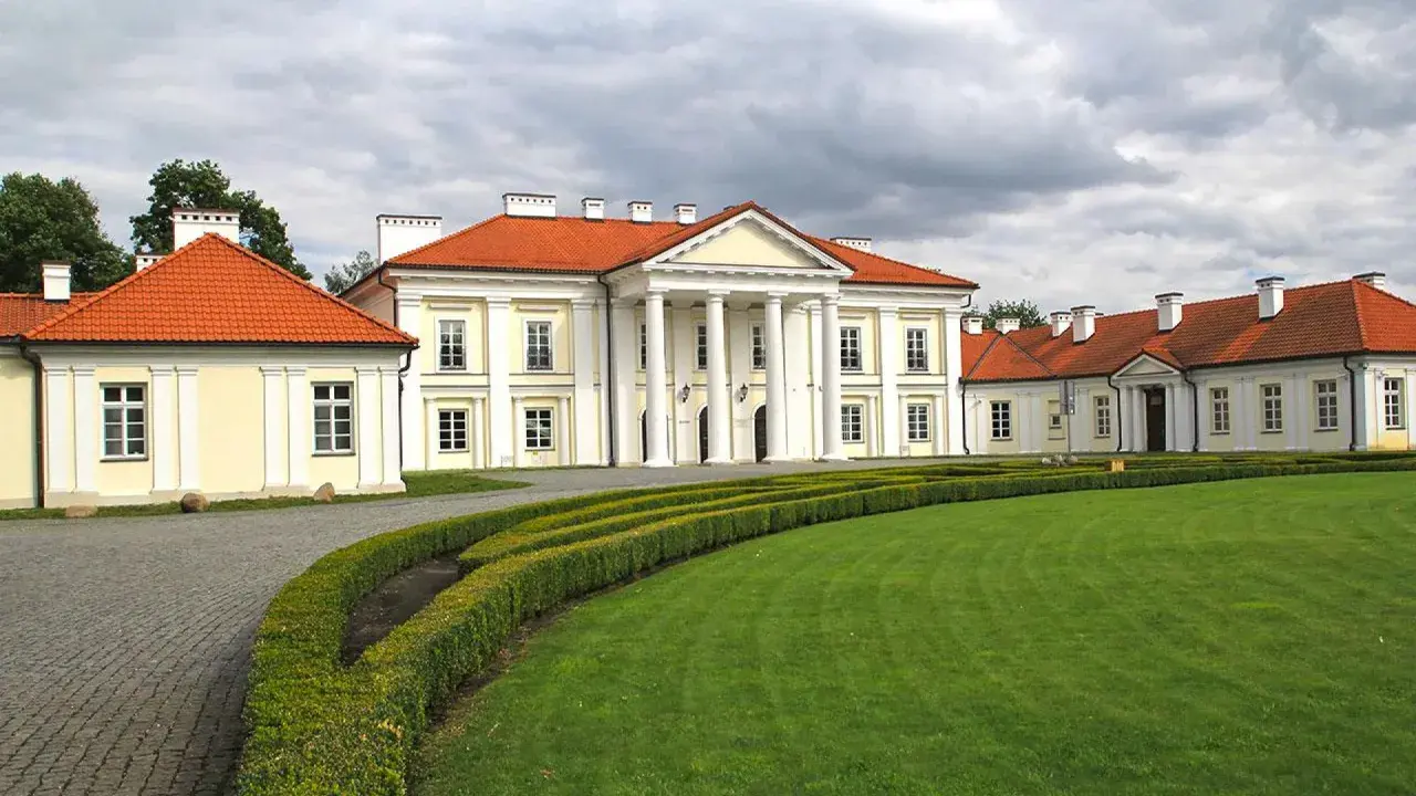 Pałac w Siedlcach, jeden z pięknych zabytków, otoczony zielonym ogrodem i ozdobnymi żywopłotami.