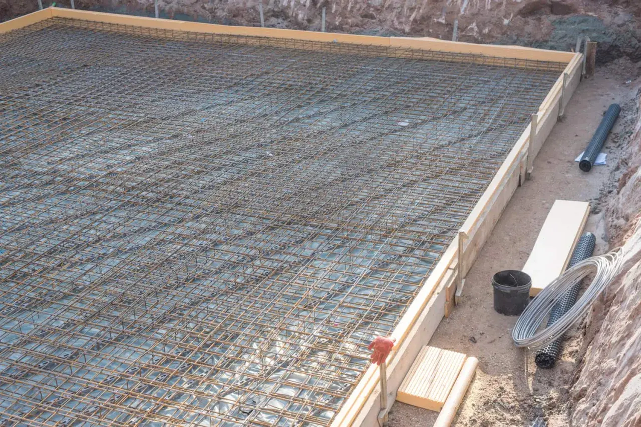 Bewehrung für eine Bodenplatte, vorbereitet in einer einseitige schalung. Stahlmatten liegen bereit für den Beton.