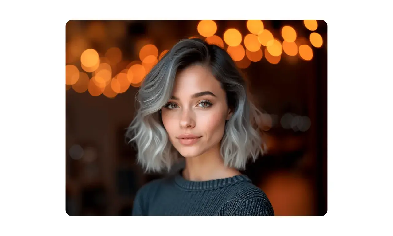 Mujer con pelo corto rubio platino ceniza, mirada cautivadora y luces de bokeh cálidas de fondo.