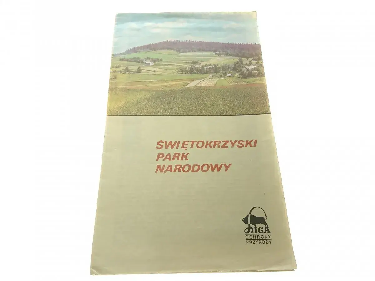 Okładka przewodnika po Świętokrzyskim Parku Narodowym z malowniczym krajobrazem i logo ochrony przyrody.