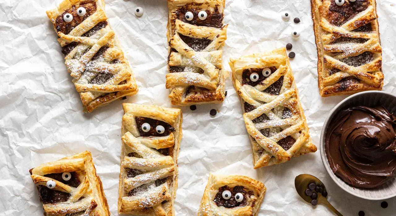 Leckere Mumien-Törtchen mit Schokocreme, ein tolles Rezept für Halloween! Mit Zucker bestäubt und lustigen Augen.