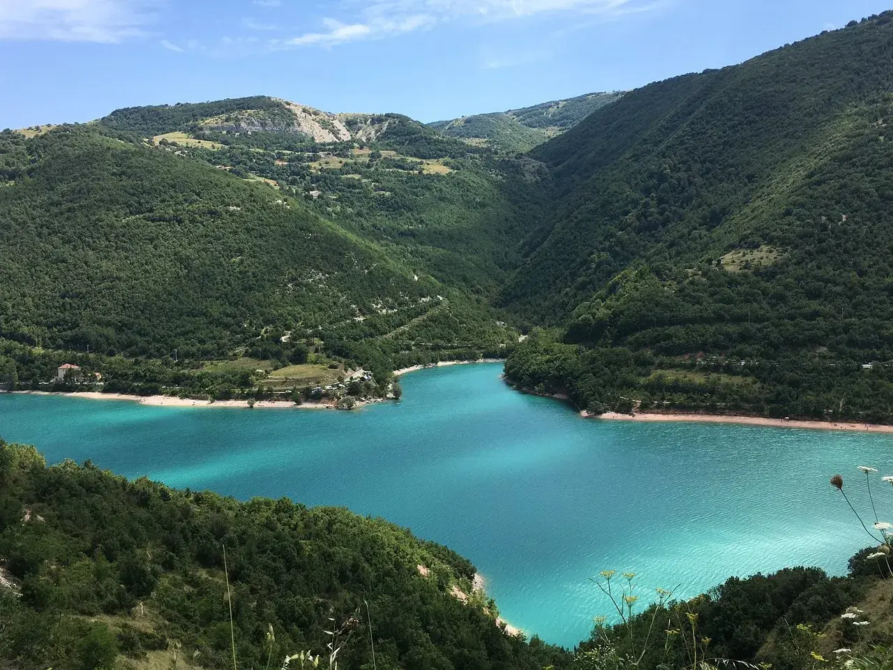 Un lago turchese incastonato tra le verdi marche montagna. Un paesaggio mozzafiato che invita alla serenità.