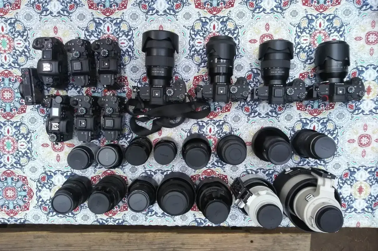 Kolekcja aparatów i obiektywów, w tym teleobiektyw. Zastanawiasz się, teleobiektyw co to? To obiektyw o długiej ogniskowej, idealny do fotografowania odległych obiektów.