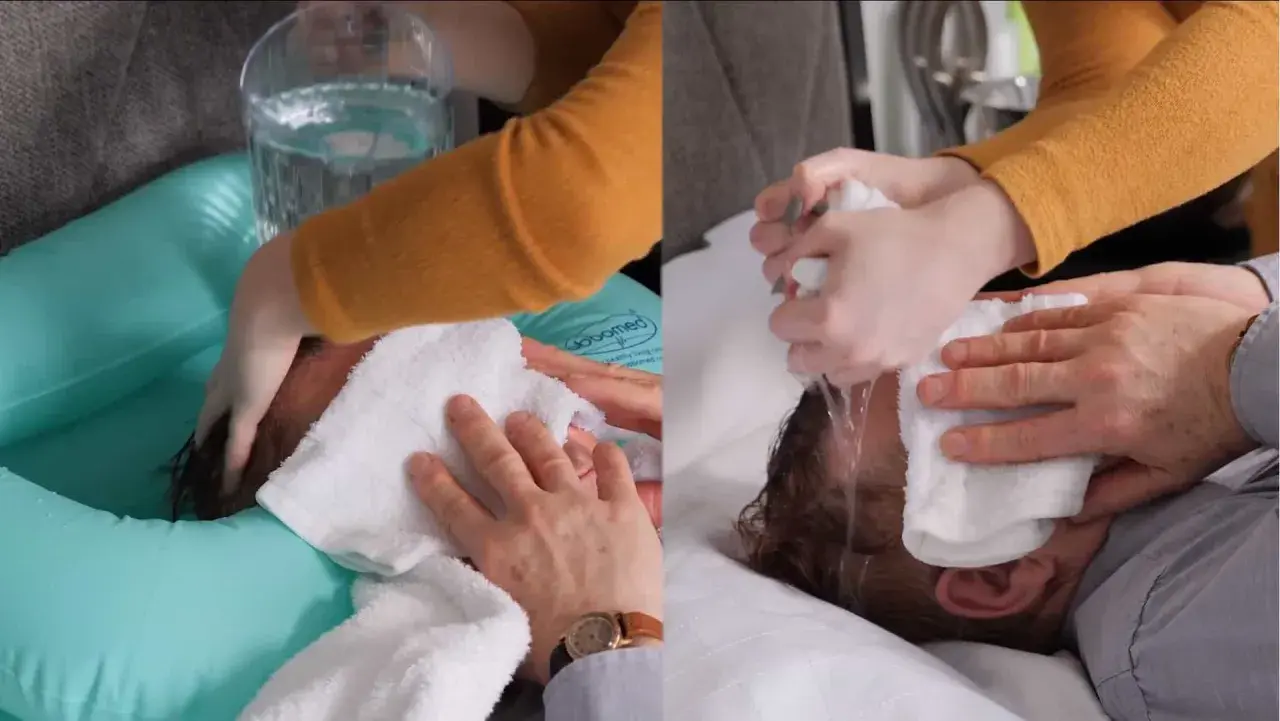 Demostración de cómo lavar el pelo a una persona encamada con una tina inflable y toallas.