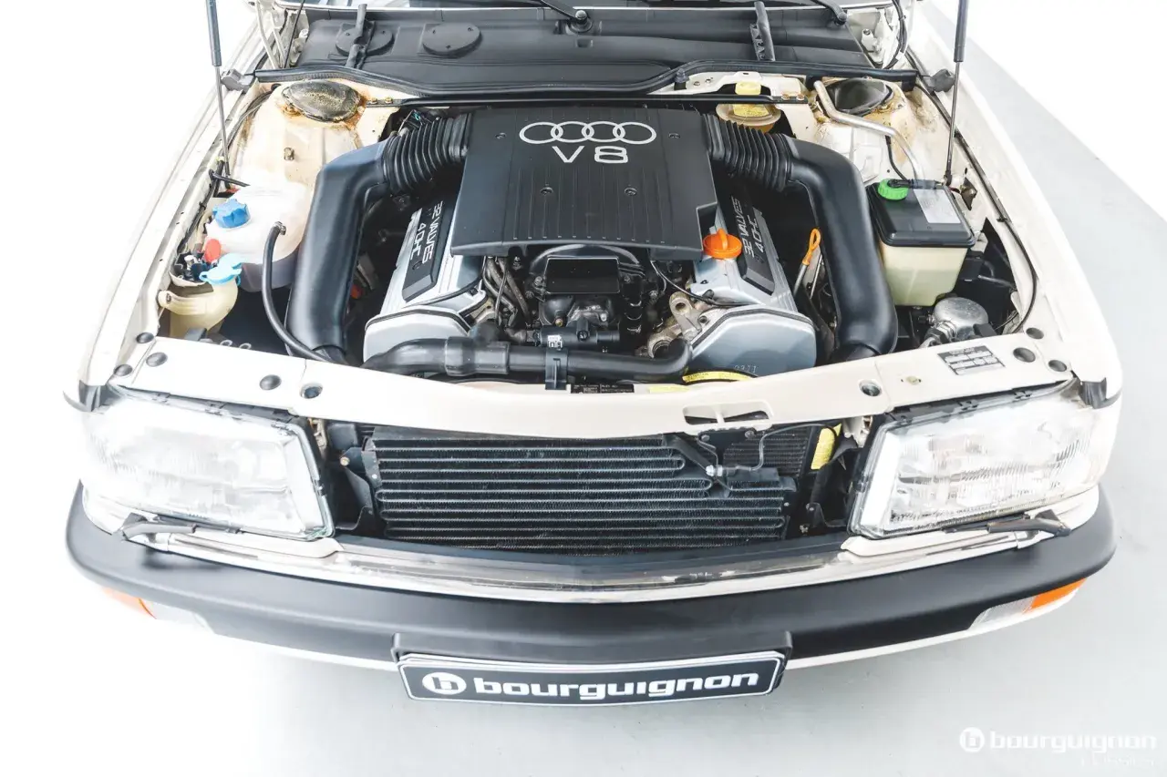 Silnik V8 Audi, potężna jednostka napędowa z lat 90. z widocznymi przewodami i elementami chłodzenia.