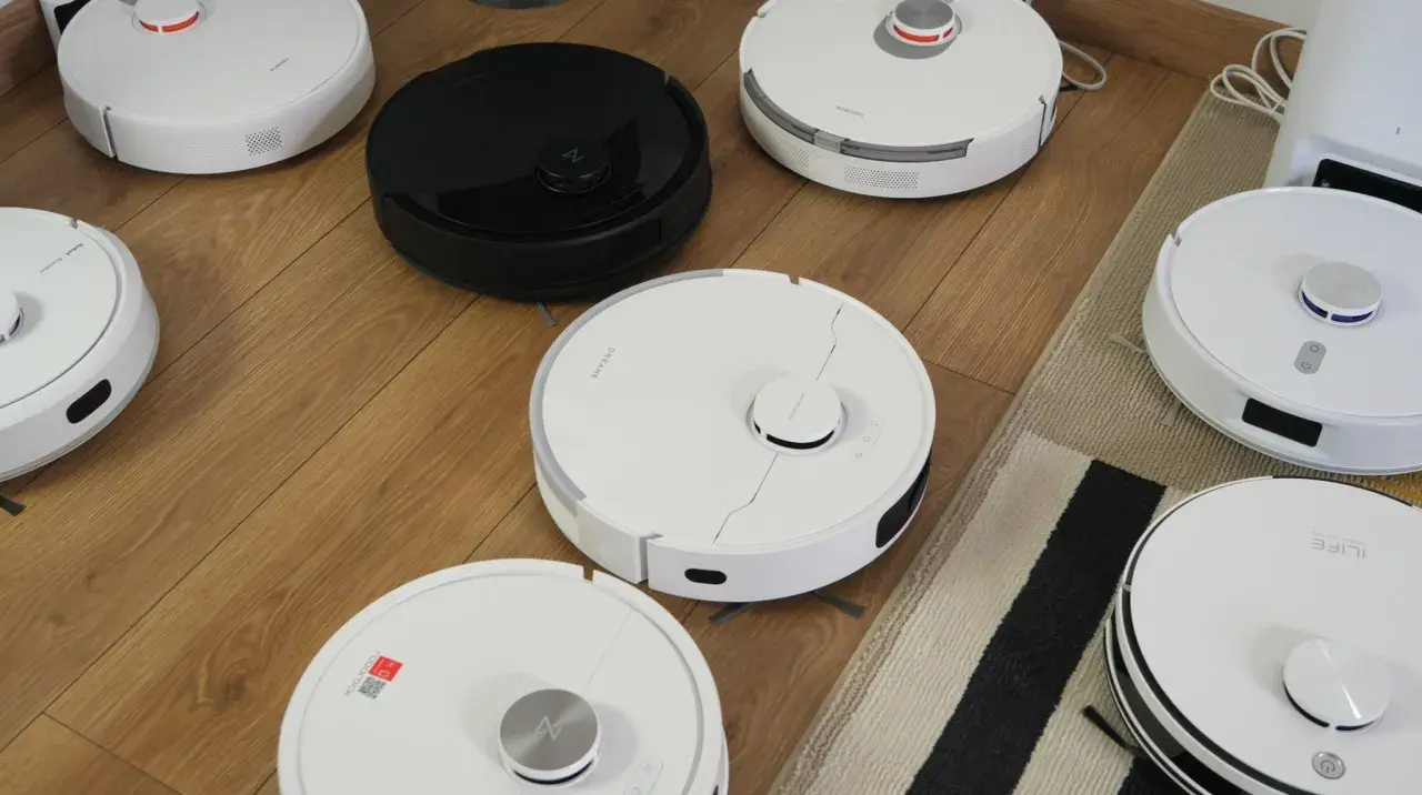 Różne roboty sprzątające na drewnianej podłodze, przygotowane do rankingu.