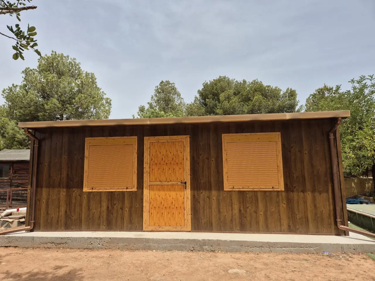 Modernas casas panel sandwich en Valencia, con acabado imitación madera y ventanas con persianas.