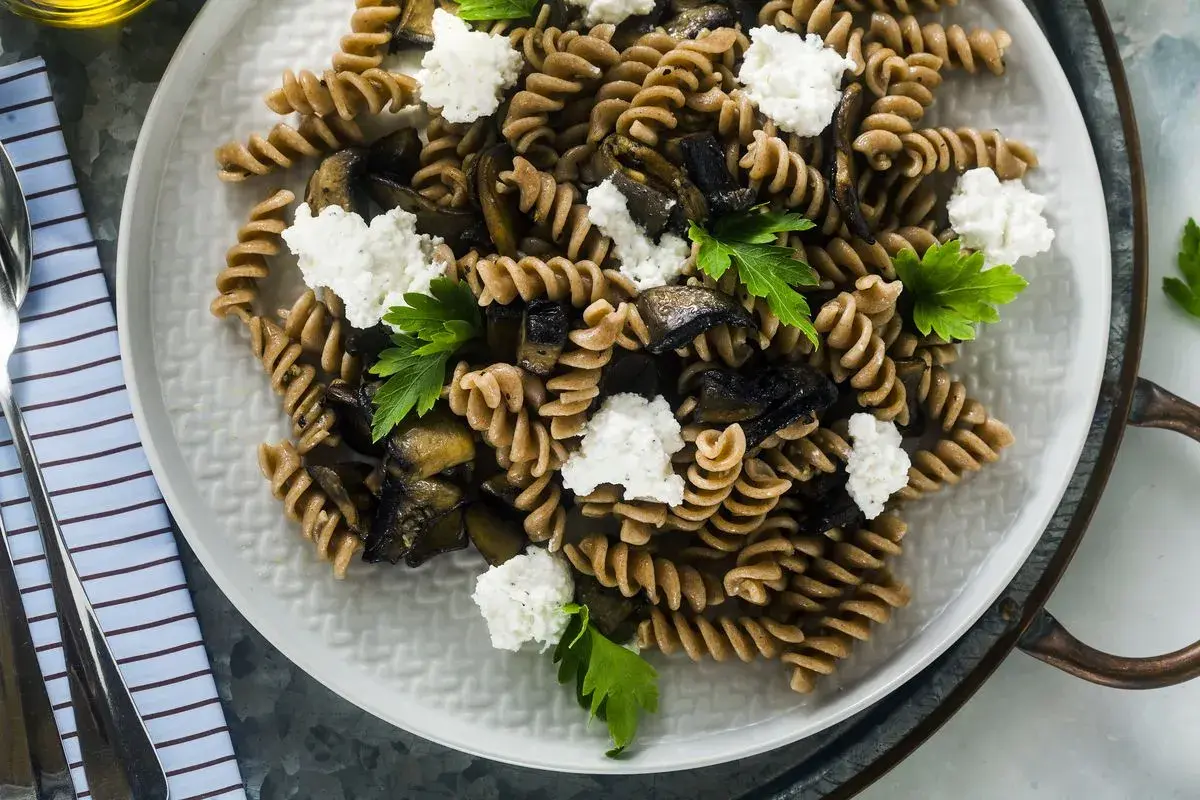 Fusilli integrali con melanzane grigliate, ricotta fresca e prezzemolo. Un piatto estivo leggero e gustoso.