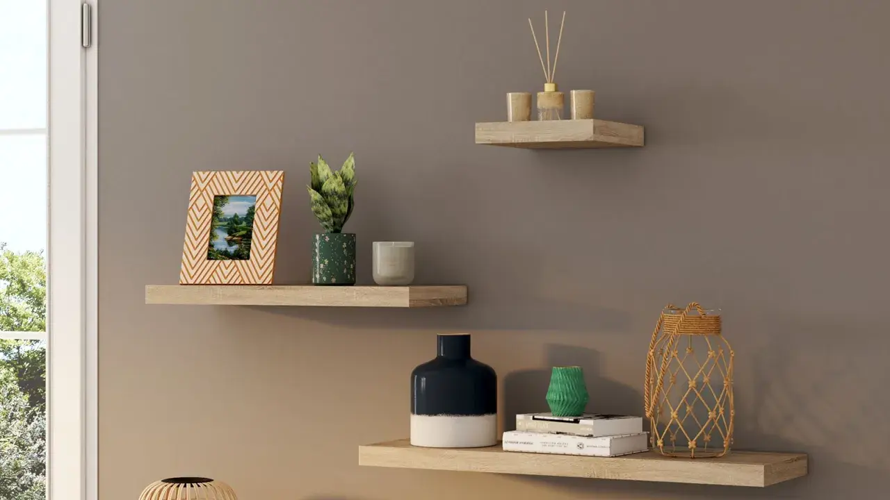 Trois étagères murales en bois clair décorées d'objets : cadre photo, plantes, bougies, vases, livres et diffuseur.