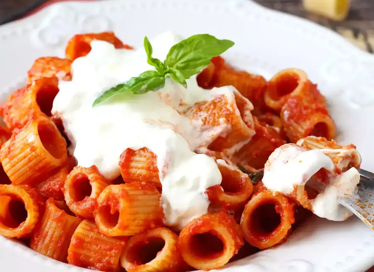 En krämig portion rigatoni med tomatsås och en generös klick stracciatella pasta, toppad med färsk basilika.