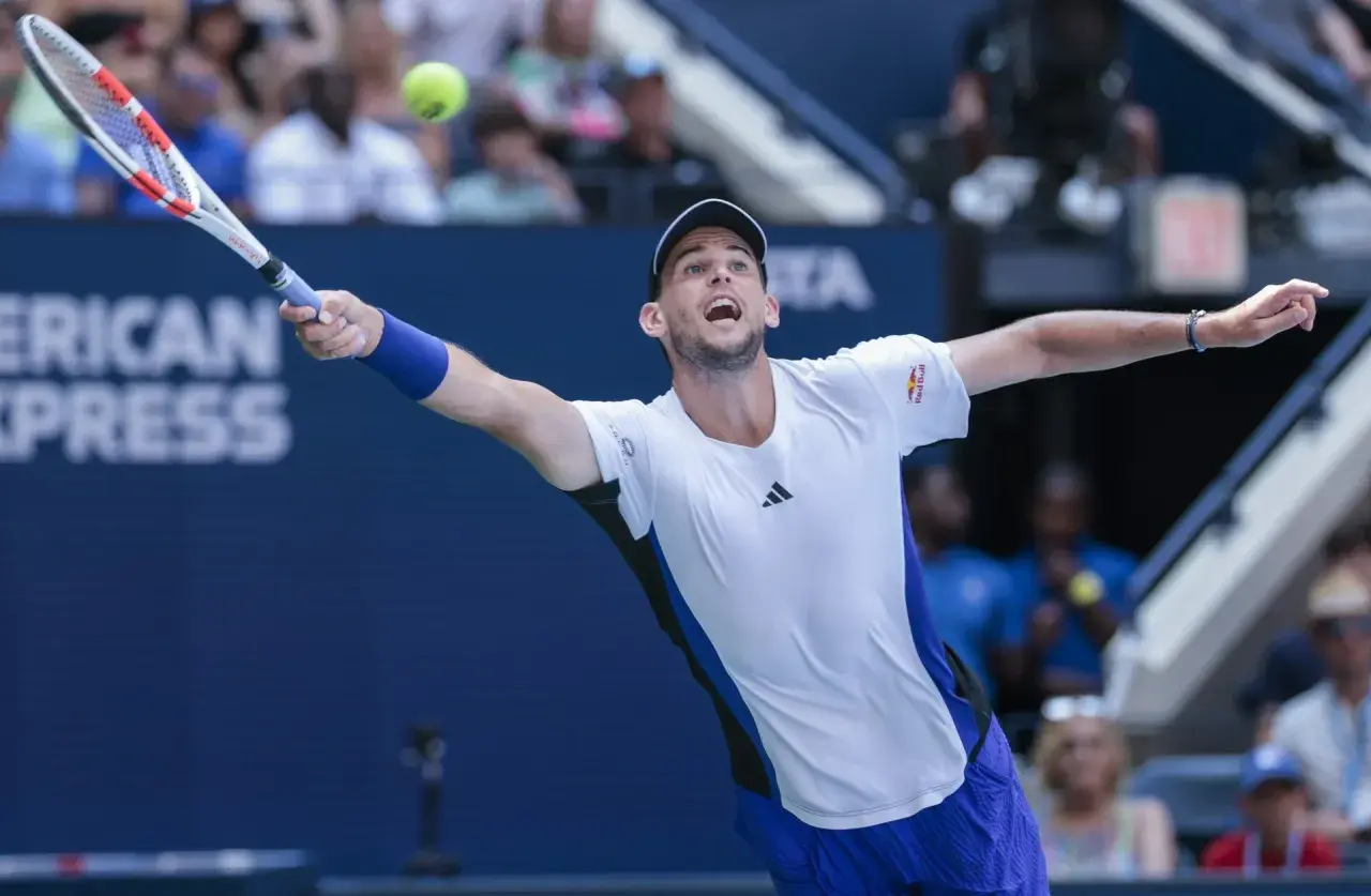 Dominic Thiem w akcji, uderza piłkę rakietą na korcie tenisowym.
