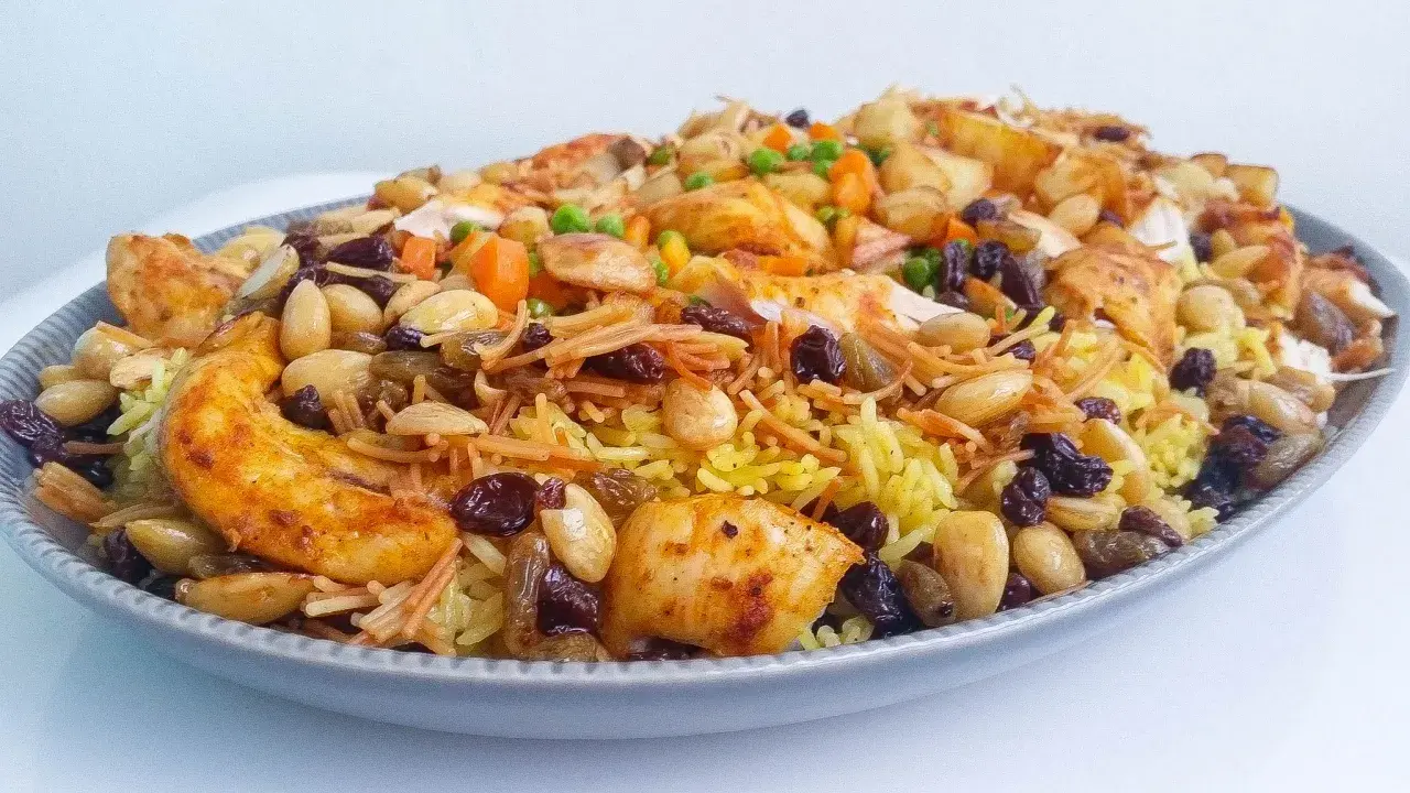 En stor portion av en läcker biryani med kyckling, ris, nötter och russin. Ett perfekt biryani recept för en festmåltid.