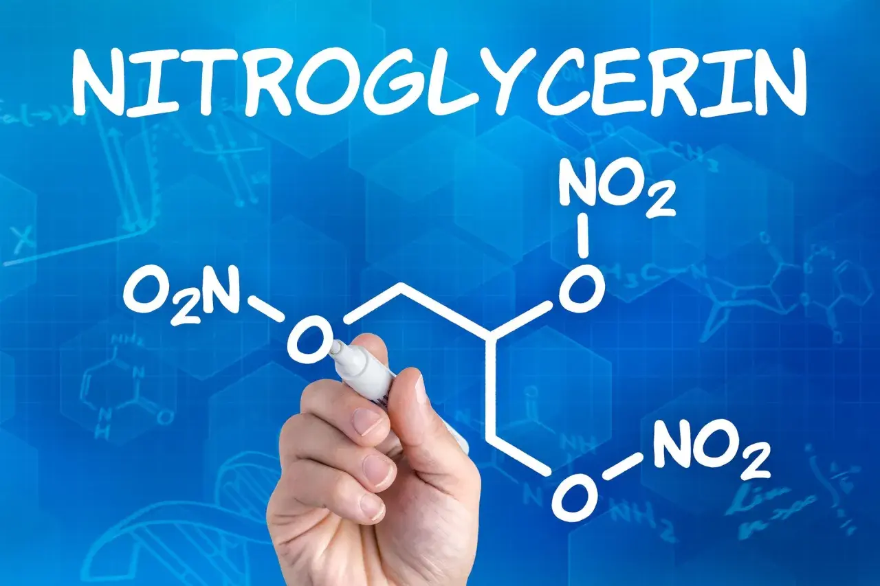 Rysunek przedstawia wzór chemiczny nitrogliceryny, z ręką piszącą markerem.