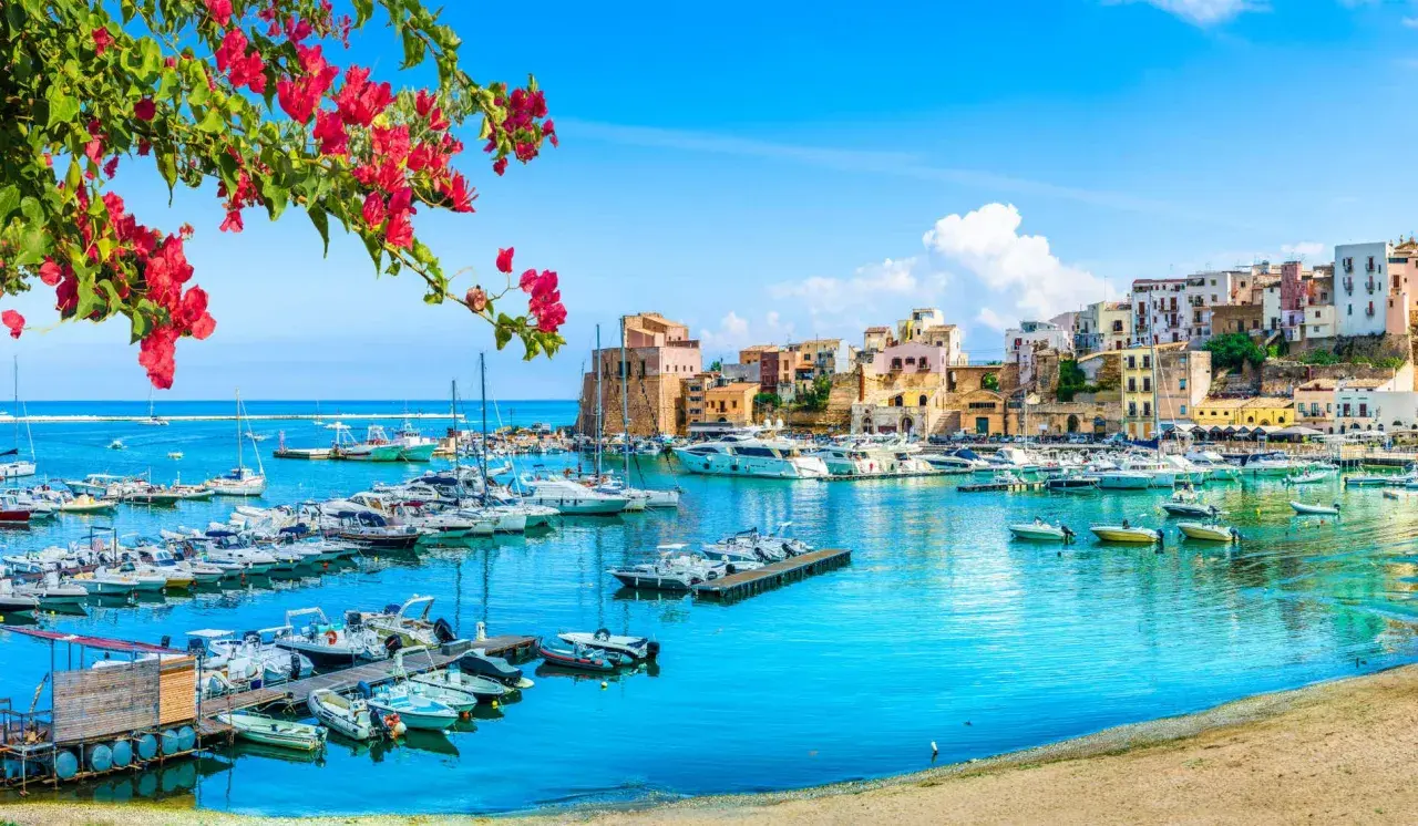 Un puerto vibrante con barcos y casas coloridas, ideal para tu plan de "Sicilia en 7 días".