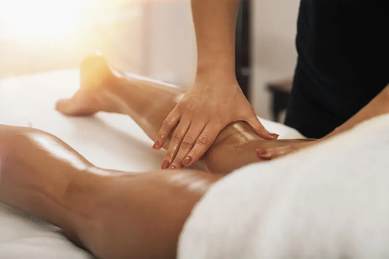 Massage des jambes pour aider à la circulation lymphatique. Un soin qui montre à quoi sert la lymphe pour le bien-être.