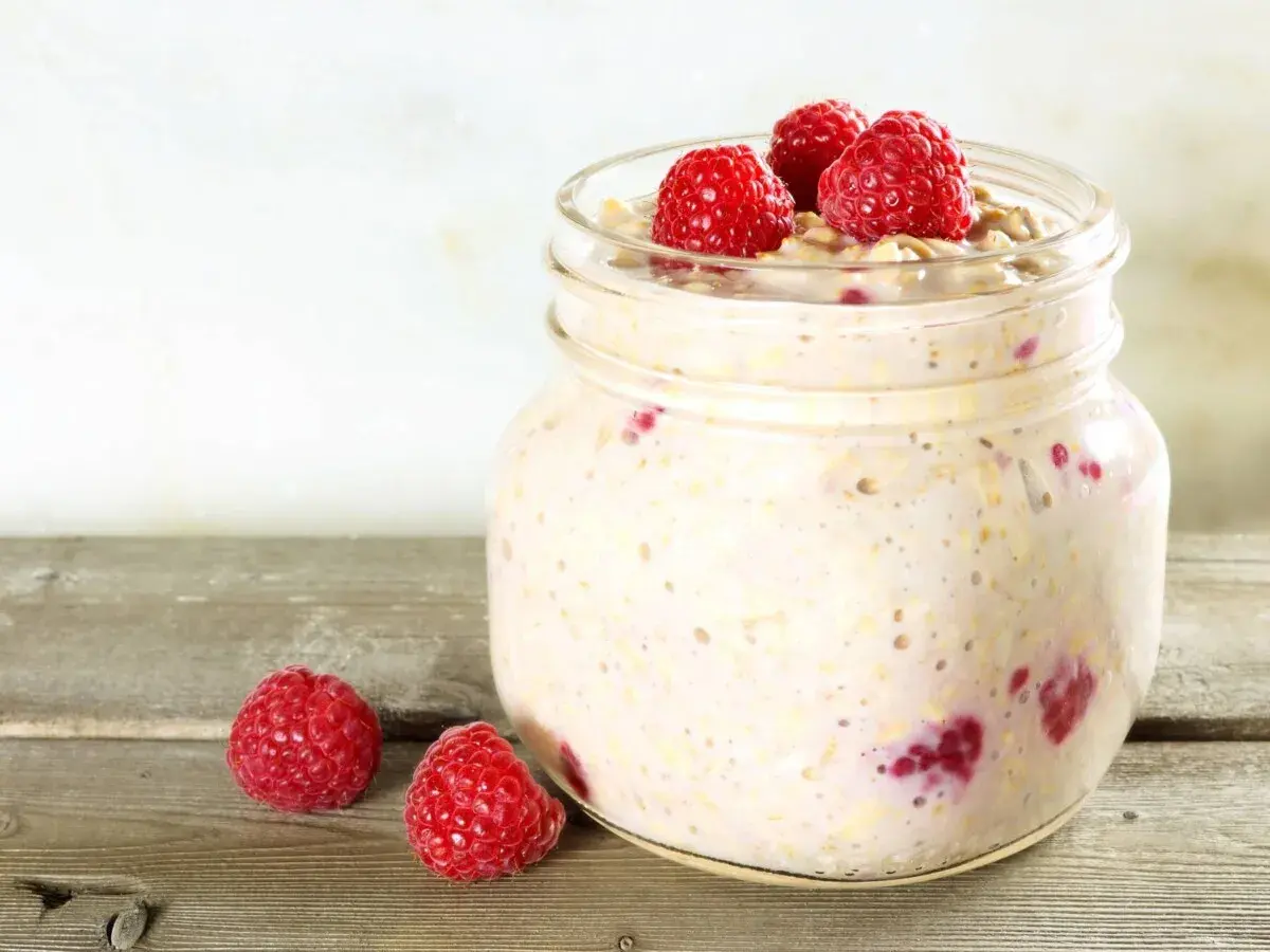 Overnight oats med proteinpulver och hallon i en glasburk, redo för en proteinrik frukost.