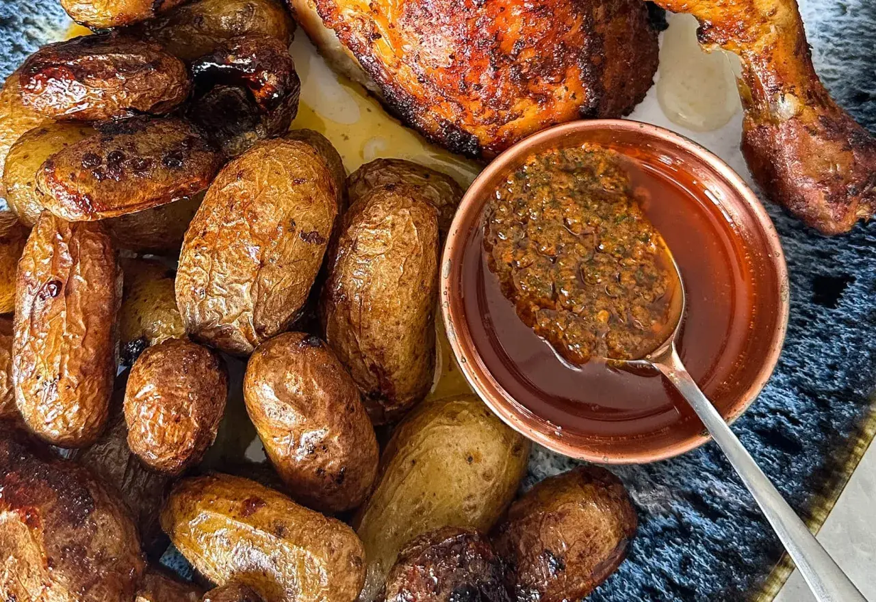 Un plat de poulet portugais rôti avec des pommes de terre dorées et une sauce savoureuse.