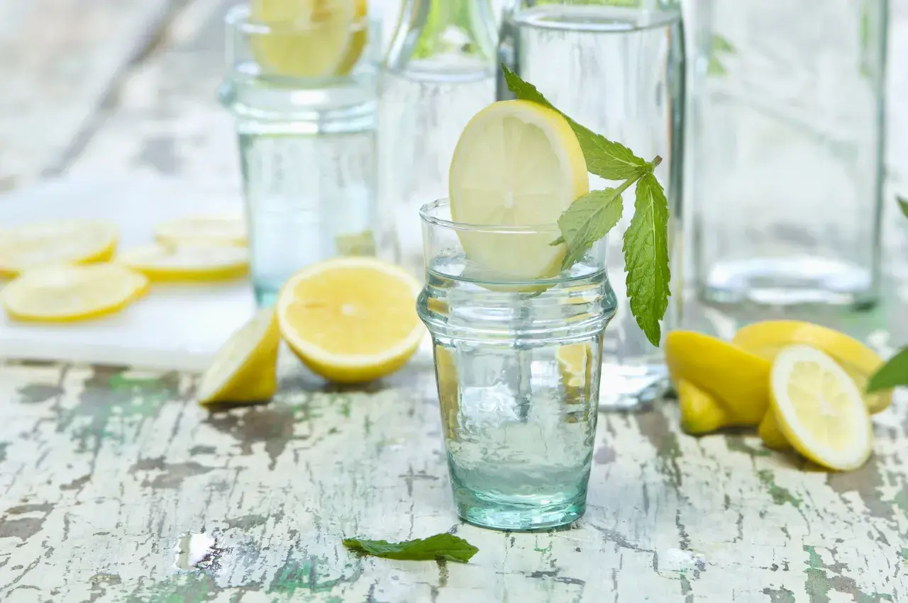 Agua con limón y menta en vasos, ideal para refrescar y para que es bueno el agua con limon: digestión y vitalidad.