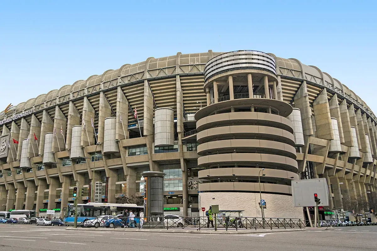 Imponujący stadion Realu Madryt, Santiago Bernabéu, z charakterystyczną betonową fasadą i okrągłą wieżą.