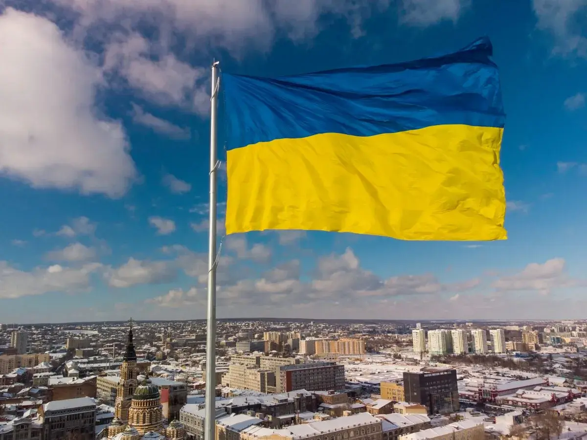 Ukraińska flaga powiewa nad miastem. Chcesz wiedzieć, jak wysłać paczkę na Ukrainę?