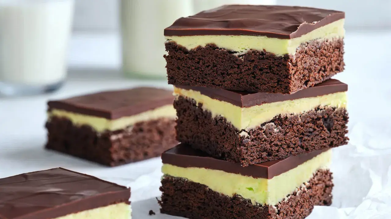En stapel chokladiga brownies i långpanna med mintgrön fyllning och chokladglasyr. Perfekt för fikat!