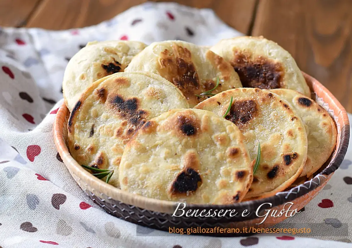 Focaccia senza lievito dorata e fragrante, servita in un cestino, con rosmarino e sale grosso. Perfetta per un pasto veloce e gustoso.