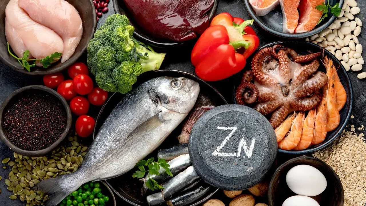 Zink ist wichtig für das Immunsystem. Auf dem Bild sind zinkreiche Lebensmittel wie Fisch, Meeresfrüchte, Huhn, Leber, Nüsse und Samen zu sehen.