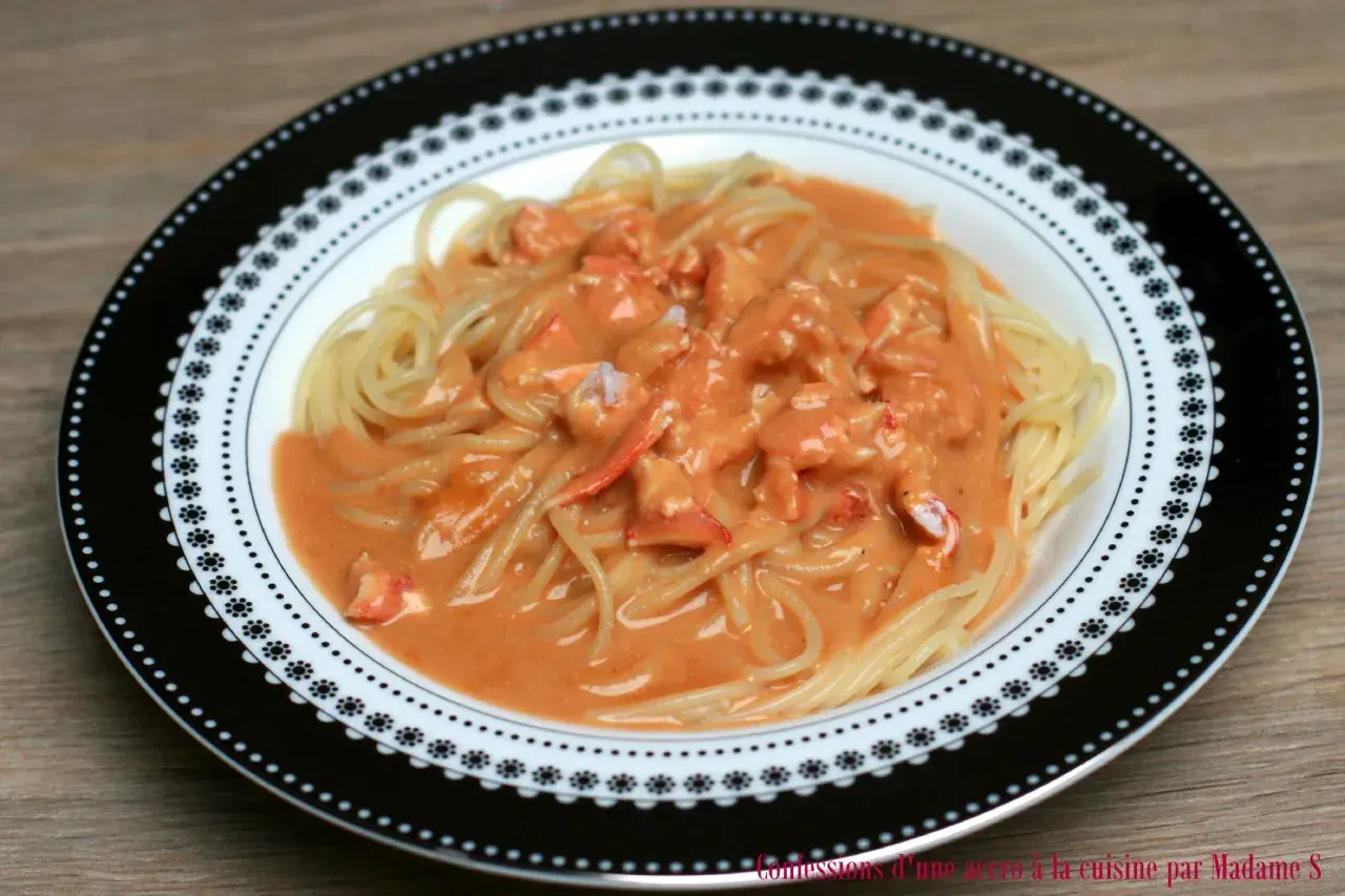 Pâtes au homard crémeuses, un délice servi dans une assiette décorée.