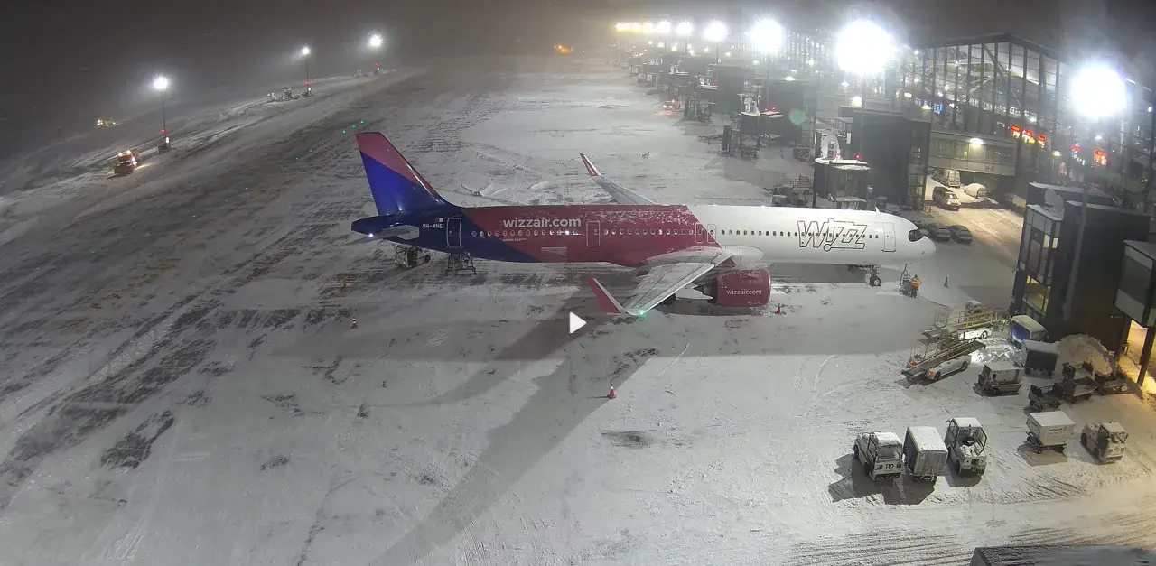 Samolot Wizz Air na lotnisku w Gdańsku, przygotowany do lotów. Śnieg na płycie lotniska.