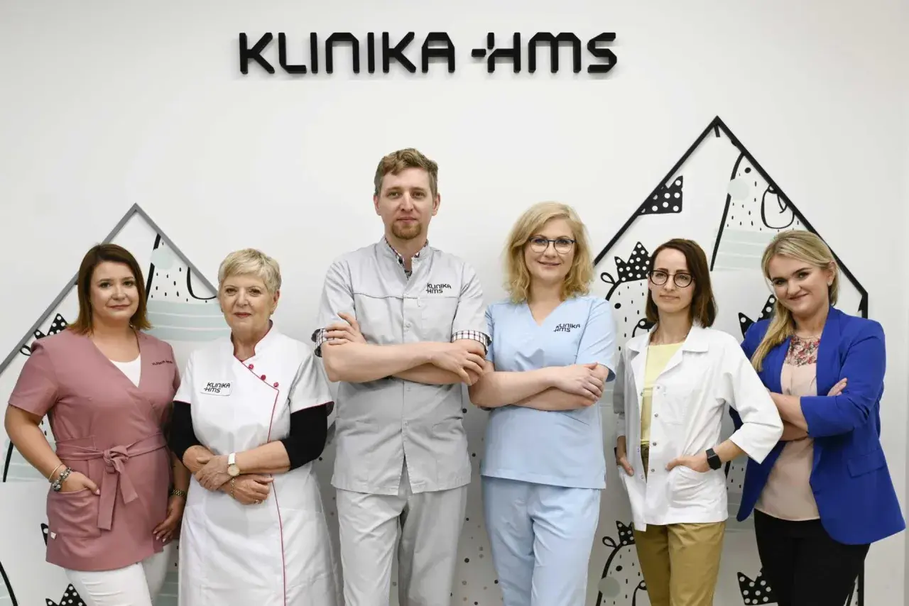 Zespół medyczny Kliniki HMS w Zielonej Górze: sześć osób w strojach medycznych i garniturze.