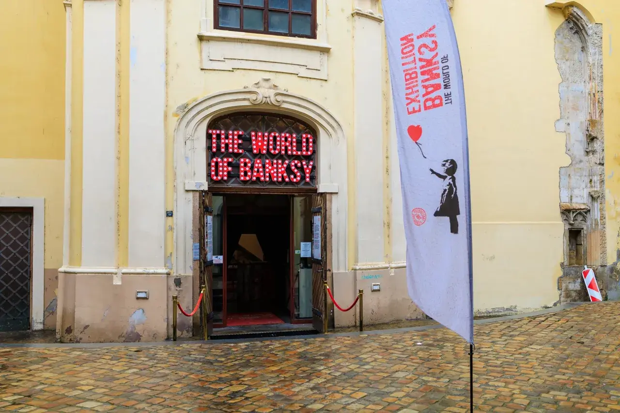 The World of Banksy" Ausstellung in Prag. Ein Banner mit dem berühmten Mädchen mit dem roten Ballon wirbt für die Schau.